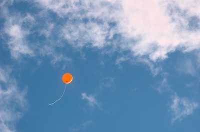 Orange baloon flying away