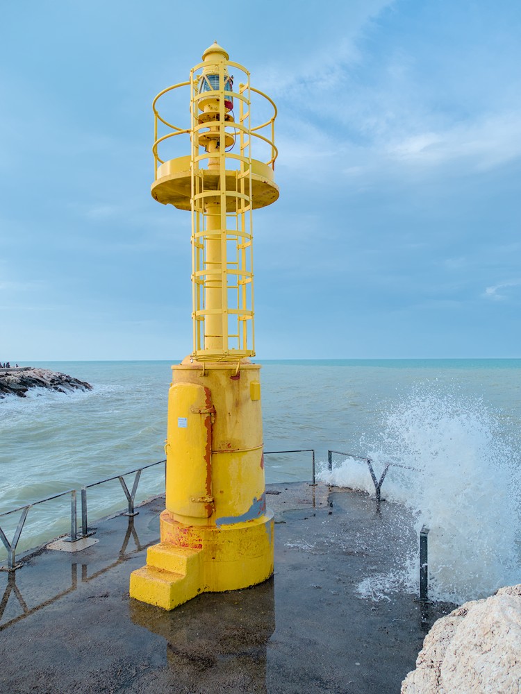 Windy sea and yellow lighthouse