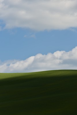 Green hill with clouds and shadows