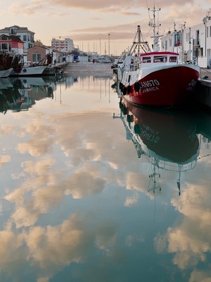 Red boat with clouds reflection