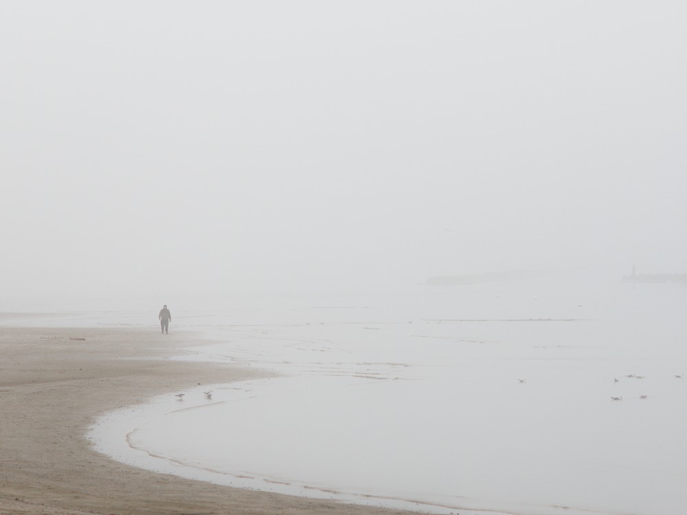Walking on the beach in winter with the fog