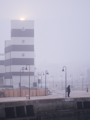 Lighthouse in the fog, at the riverbank