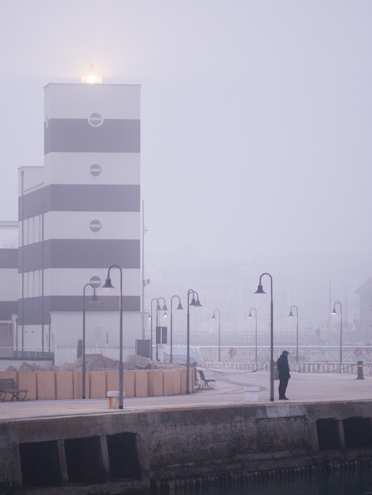 Lighthouse in the fog, at the riverbank