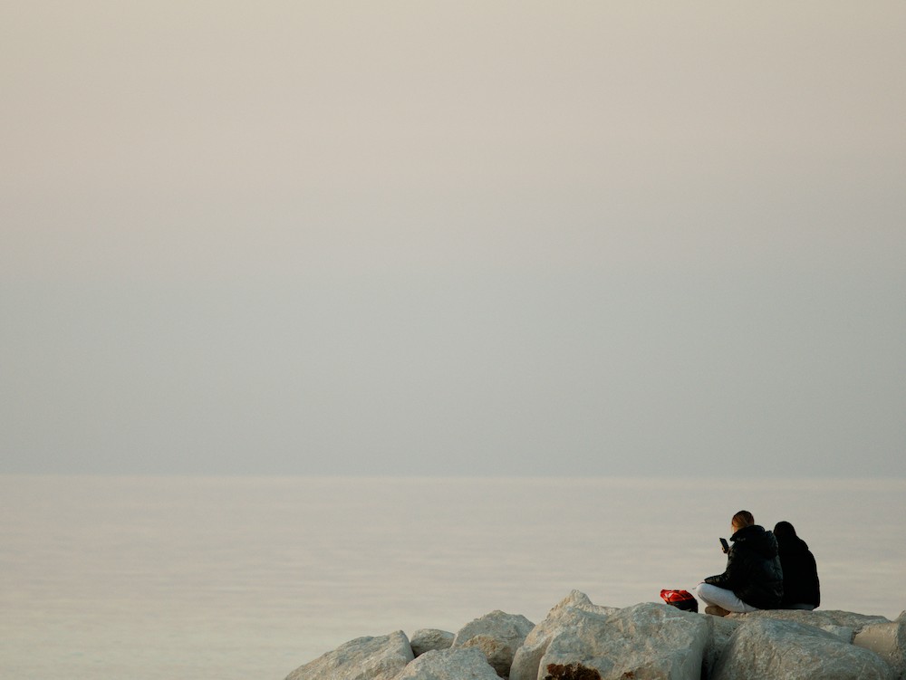 Watching the sea from the rocks at dusk