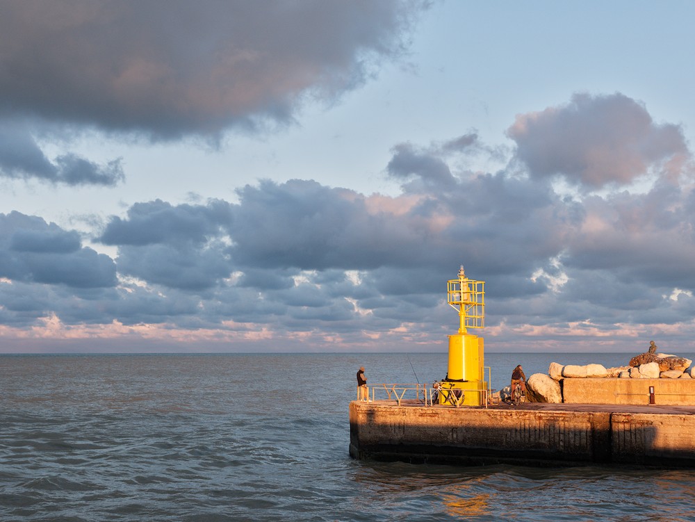 Fishing at the yellow lighthouse at sunset