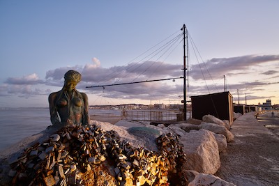 Sirenetta stature at the harbor at dusk