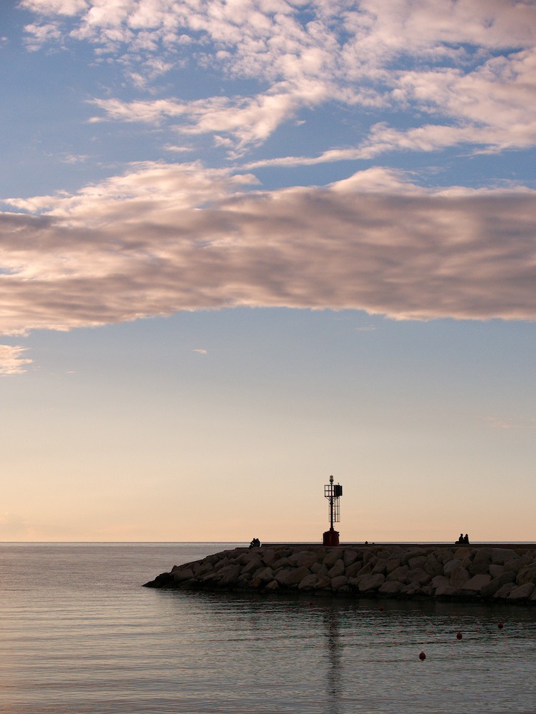Watching the horizon at the harbor at sunset