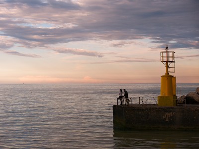 Watching the horizon at the harbor at sunset