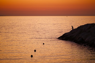 Fishing at the harbor at sunset