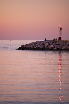 Watching the horizon at the harbor at sunset