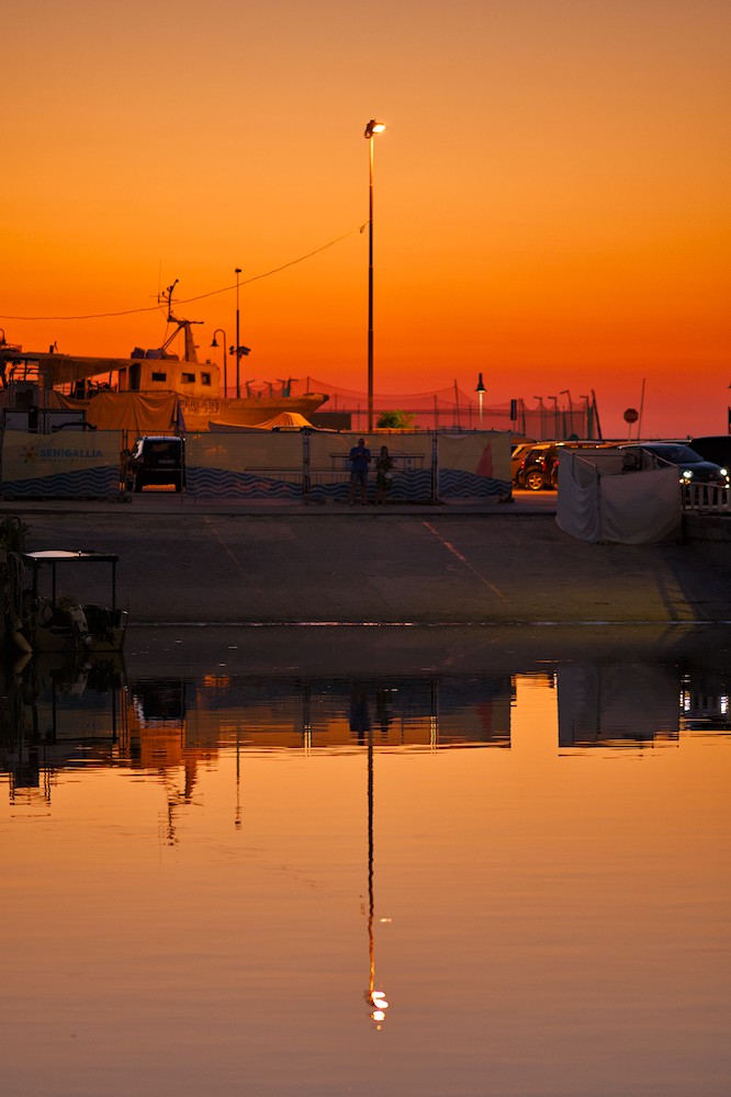 Street lamp reflection in the harbor at sunset